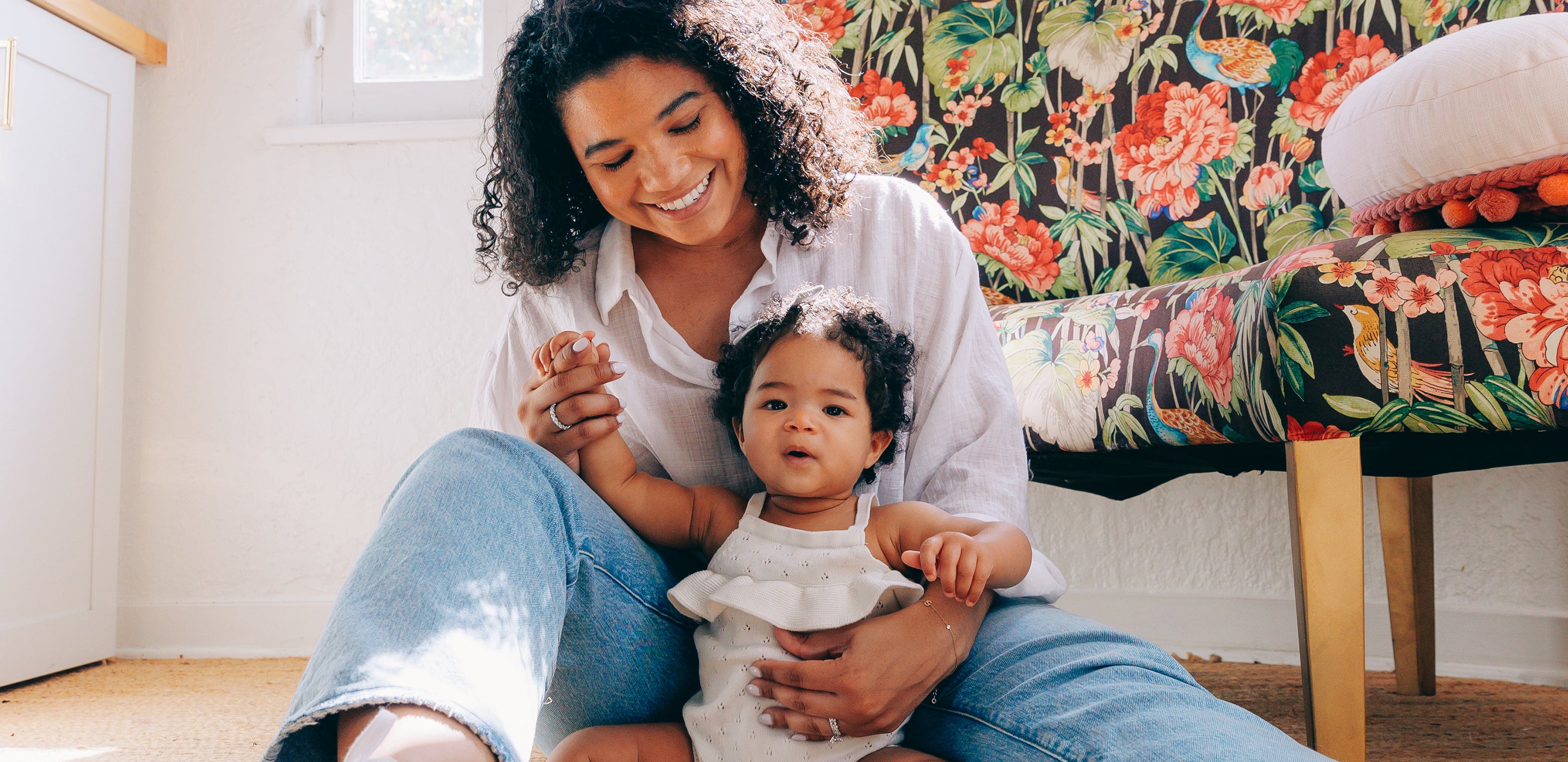 Mother holding baby on floor
